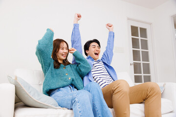 テレビで見ている日本のカップルと応援