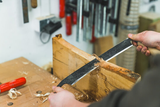 closeup shot of a male carpenter using a jack plane while working on wood in his workshop. High quality photo