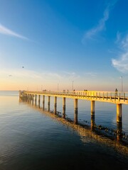 Fototapeta premium Old big pier at the sea, sunset seascape sky 