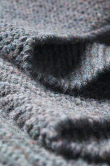 Dark gray zigzag knitted fabric. Knitted texture.