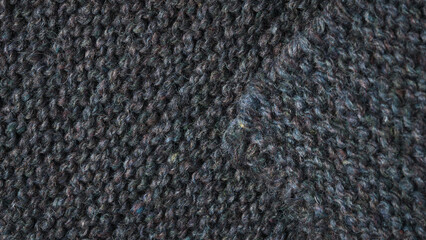 Black striped knitted fabric. Dark knitted texture background.