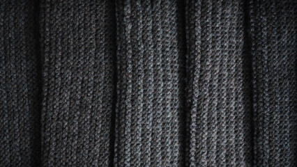 Folds of black knitted fabric. Knitted texture background.