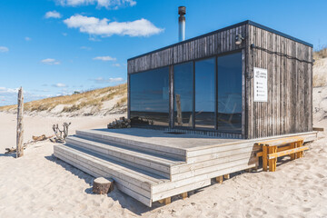 Beautiful modern wooden sauna on a white sandy beach for renting with view on the Baltic Sea and...