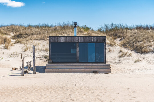 Beautiful modern wooden sauna on a white sandy beach for renting with view on the Baltic Sea and cloudy sky in Palanga, Klaipeda, Lithuania