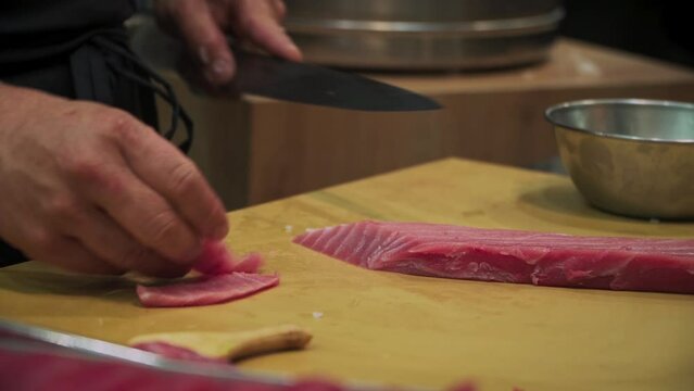 Japanese Delights: A Professional Chef Cutting Fresh Fish for Sushi. Sushi showcases culinary artistry, with skilled chefs meticulously crafting each piece
