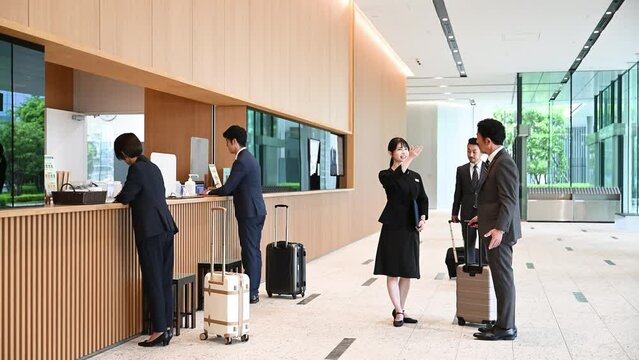 接客業の女性とビジネスマン　ホテルの受付やコンシェルジュなどが案内するビジネスや旅行の出張シーンの動画