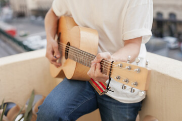 unrecognizable guy in white shirt playing acoustic guitar - obrazy, fototapety, plakaty