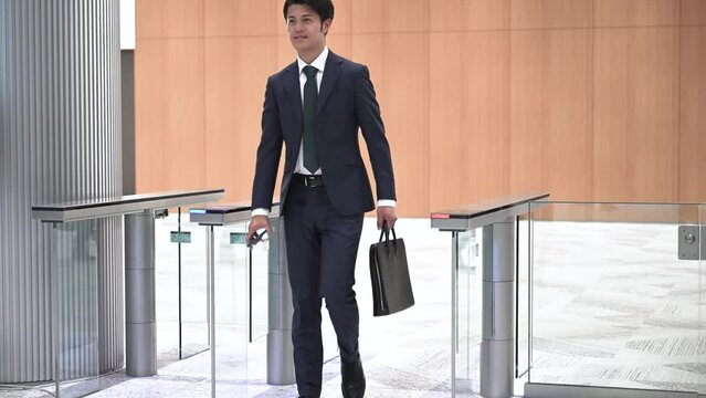 Video of people going through the gate at the entrance of a company with a smartphone or card key Business scene of going to work or commuting to work