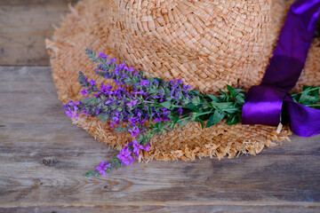 Obraz na płótnie Canvas romantic straw hat, bouquet of purple wildflowers, concept outdoor tea party, good weather, cozy mood, beautiful base for designer