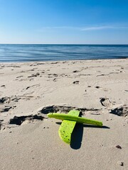 Airplane toy on the white sandy beach, blue seascape
