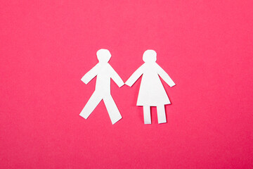 Man and woman relationship, love and family concept. Paper human figures on a pink background
