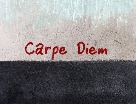 Old grunge wall with red handwritten text  CARPE DIEM, means to seize the day, making life extraordinary, to remind self to enjoy the life while still can