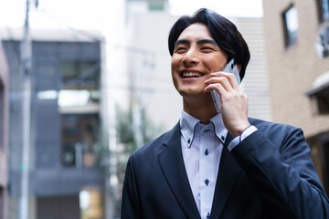 電話で話している日本人男性