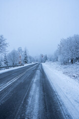Fototapeta na wymiar Country road in snowy winter day