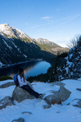 Tourist woman near the mountain lake Morskie Oko in Tatra National Park, Poland. Young happy hiker...