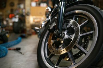 Fototapeta na wymiar Closeup on motorcycle wheel in workshop, showroom for sale or garage service