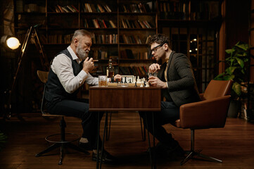 Family of intelligent people playing chess, smoking cigars and drinking whiskey