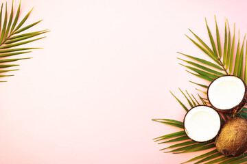 Summer flat lay background. Palm leaves and coconut on pink background.