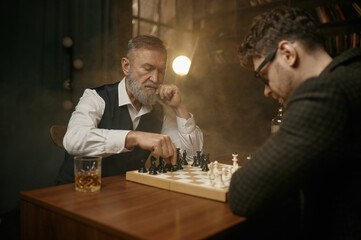 Pensive chess player moving the figure