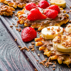 Fototapeta premium strawberries and bananas on wafers with chocolate paste