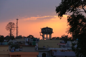 Sunset at Dehradun City. Orange color sky background with dark trees silhouette.