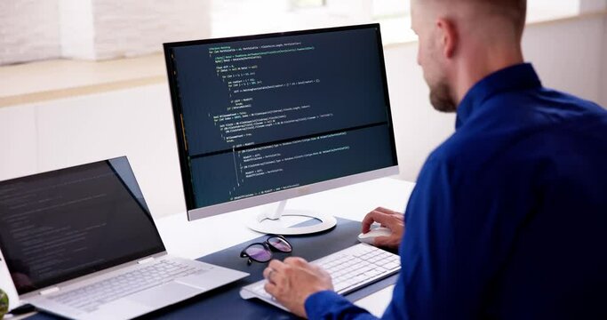 Computer Programmer Writing Program Code On Computer