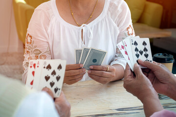 Retired people playing card in a retirement home.