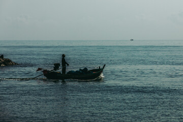 Fishing boat and fisherman at sea or ocean water.