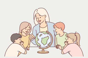 Teacher with children near globe study geography during lesson in elementary school