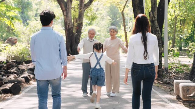 Happy Asian family come to visit grandfather and grandmother talking and entwining in the park, family warmth concept