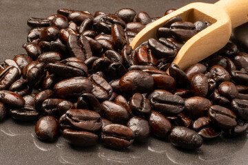 Dark roast coffee beans on a black background