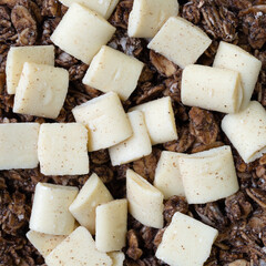 Close view of a portion of sweet chocolate granola with white chocolate pieces.