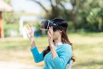 Young Asian woman gamer wearing virtual reality touching air during the VR experience  Future home technology player hobby playful enjoyment concept