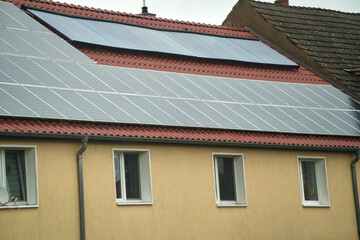 Obraz premium Water solar collector on a red metal roof. Solar thermal and solar panel for hot water.