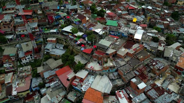Comuna 13 Medellin Colombia graffiti and pablo escobar tour, escaleras electricas tourist attraction. people walking. zoom out drone shot favela
