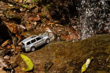 Concept for traveling and adventure. A toy car on a giant rock, after some edits.