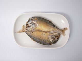 Two fried mackerels on a white plate