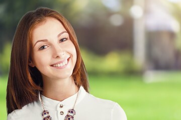 Happy young beautiful woman posing on natural background