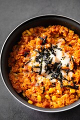 A bowl filled with a vegan-friendly combination of rice and corn, garnished with herbs and spices