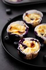 Appetizing image of delicious blueberry muffins served on a black plate