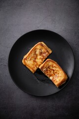 Appetizing grilled cheese toast sandwich displayed on a black plate, ready to be enjoyed