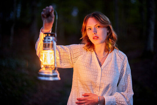danish girl with lamp in forest