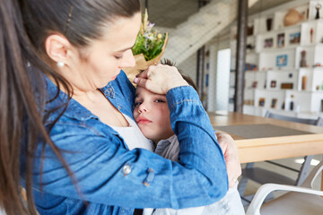 Obraz premium Mother caringly takes care of sick son