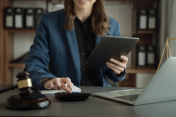 Fototapeta premium Lawyer or accounting department writes a note and uses a calculator to calculate expenses - income. at office lawyer.