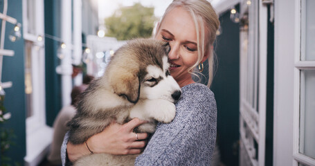 Dogs, trust and a woman carrying her pet in the home as a companion for love, safety or friendship. Happy, dog and a female animal owner holding her purebred husky puppy over her shoulder in a house © Kobus Louw/peopleimages.com