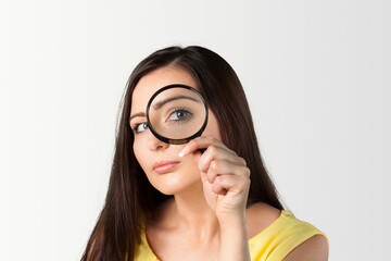 Happy young women entrepreneurs looking in magnifying glass