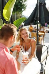 Young couple sitting in a cafe and speaking. Students during break in the cafe place.Enjoying a great first date.