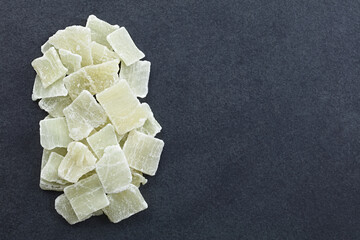 Candied or crystallized aloe vera gel slices photographed overhead on slate with copy space on the side