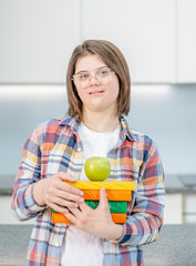 Portrait of a young girl with Downs syndrome holding books