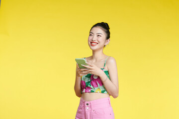 Photo of pretty excited girl dressed cropped top reading cell phone isolated on yellow background